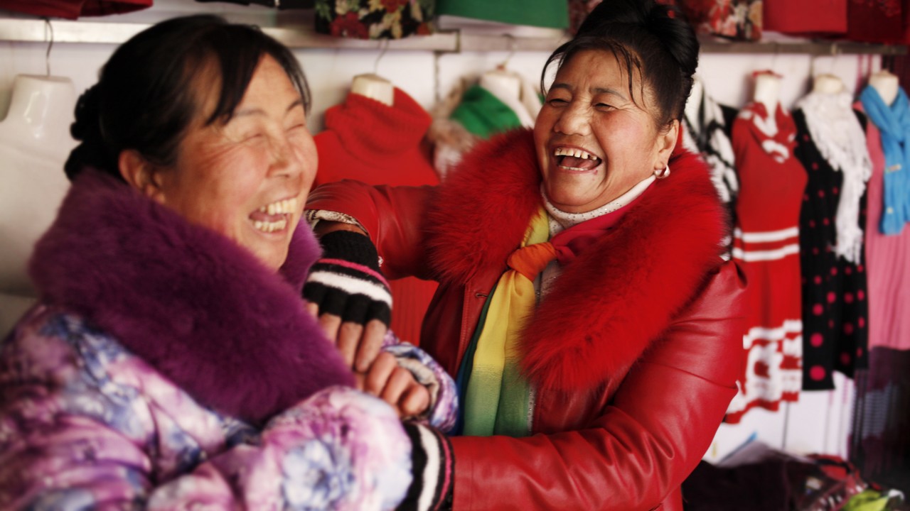 Xu Lan Xian (à droite) vient du Yunnan. Suite à un accident à la ferme quand elle était petite, elle a perdu l'une de ses jambes. Avec le temps, elle a accepté sa condition et a pris confiance. Aujourd'hui elle loue un magasin en ville pour y vendre des vêtements.