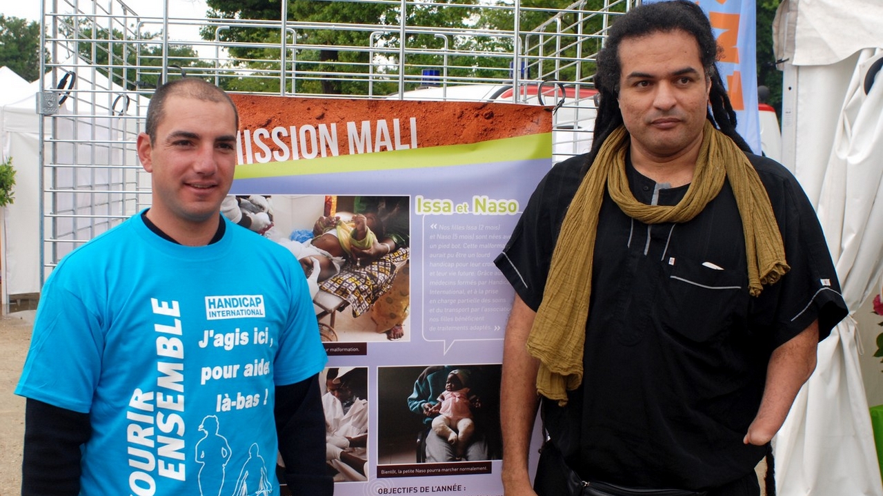 Des sportifs de haut niveau portent le drapeau « Courir Ensemble » pour soutenir Handicap International. Ici, Damien Seguin et Ryadh Sallem.