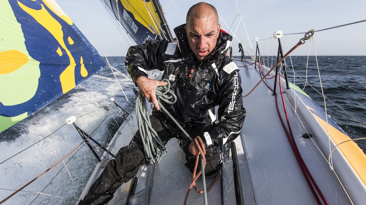 Sur un bateau en plein mer, un skipper réalise ses manœuvres.