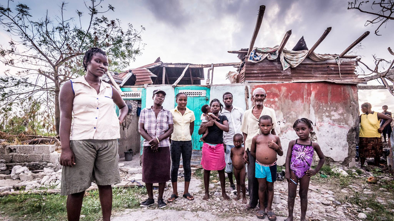 La famille d'Inès devant sa maison détruite par l’ouragan Matthew en Haïti