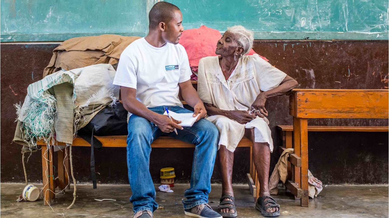 L'équipe de Handicap International avec Méralia Simon, 90 ans, qui a trouvé refuge au lycée Philippe Guerrier, aux Cayes en Haïti