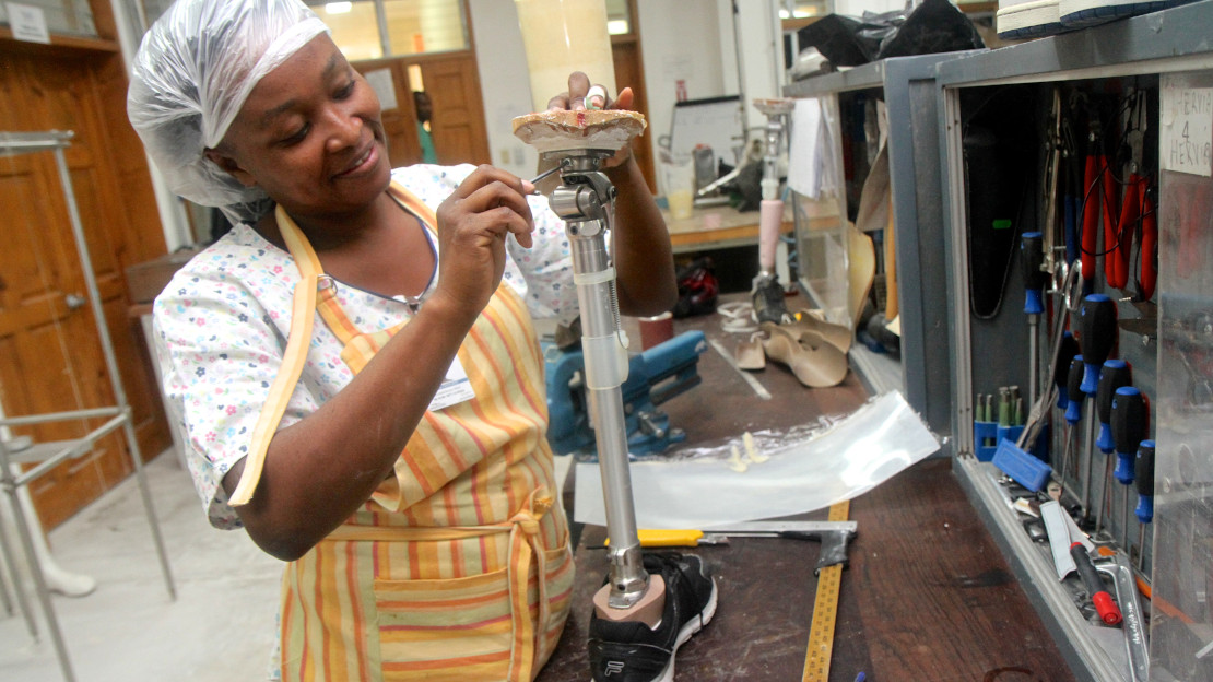Technicienne en train de finaliser une prothèse. 11 ans après le séisme en Haïti, Handicap International continue de favoriser l'accès des plus vulnérables aux services de réadaptation.