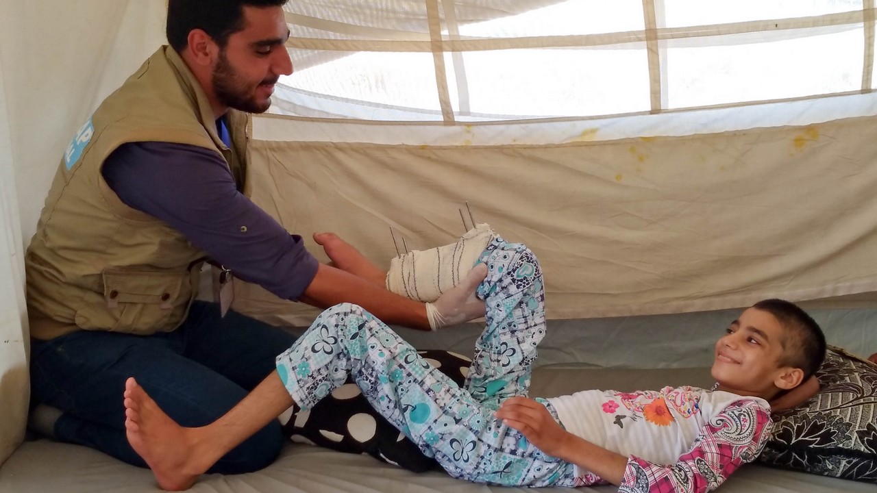 Amira dans sa tente dans le camp de Hasansham avec Mohamad, le kiné de Handicap International