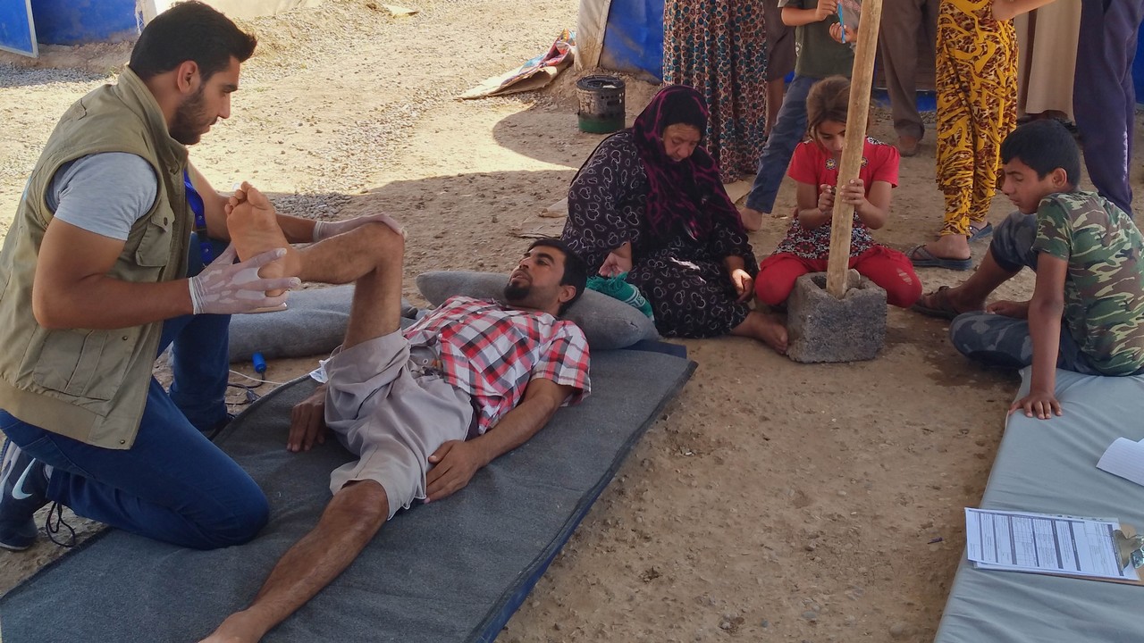 Salah en séance de réadaptation avec Mohammad dans le camp de Hasansham en IrakDans le camp de Hasansham en Irak, Salah en séance de réadaptation avec Mohammad de Handicap International