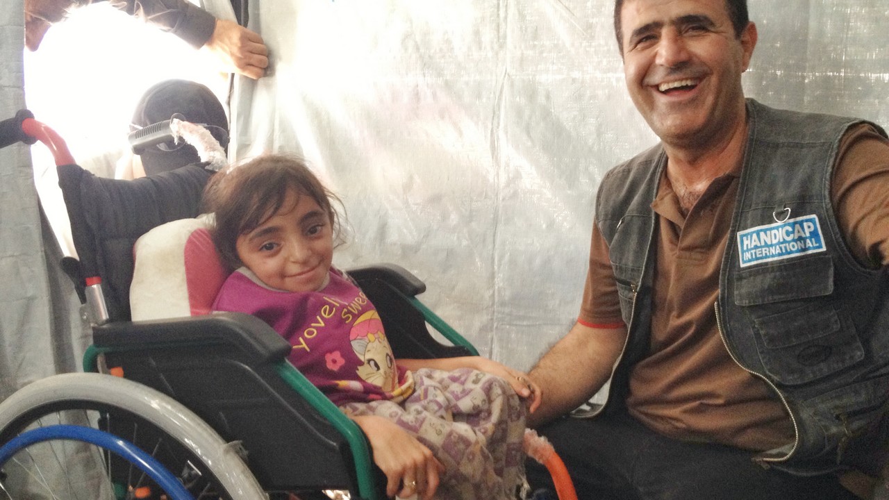 Une enfant refugiée syrienne en Irak, atteinte d'ostéoporose reçoit un fauteuil roulant de Handicap International.