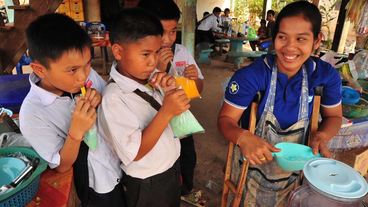 Bouachanh Douangharath, 27 ans, est propriétaire d'un petit stand de nourriture au Laos. La jeune femme a reçu des fournitures pour son stand de la part de Handicap International. Les enfants ne voient guère que la propriétaire de la boutique est handicapée.