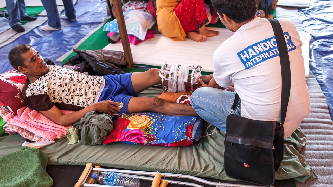 Un kinésithérapeute de Handicap International au Népal évalue la fracture d'une victime du séisme.