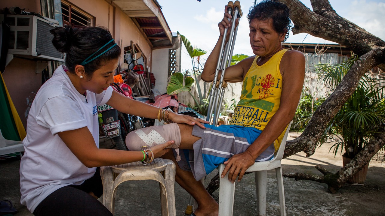 Handicap International Philippines. Iris, chef de projet Réadaptation, rend visite à Roméo dans le cadre des relais 