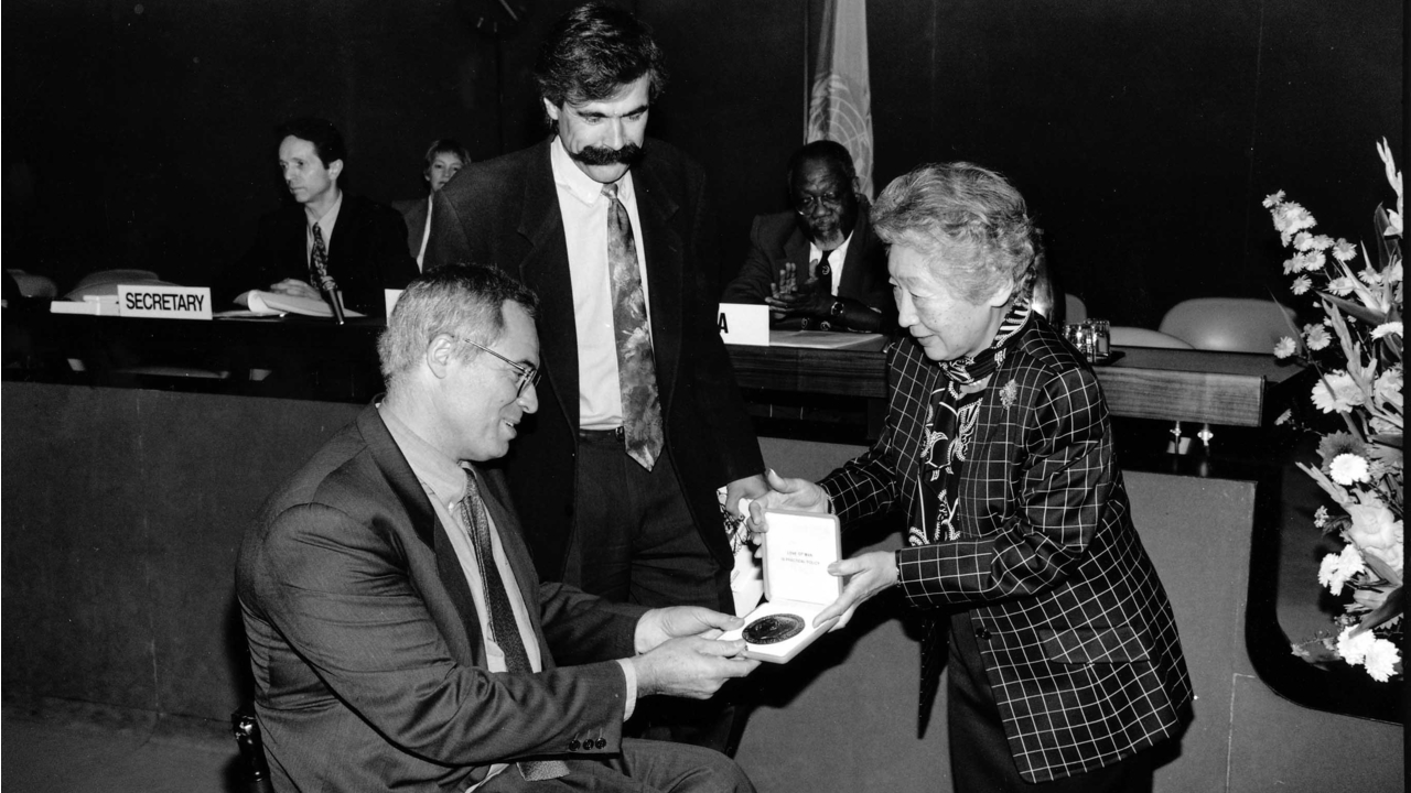 La Haut-Commissaire des Nations Unies pour les réfugiés, Madame Sadako Ogata, remettant la distinction Nansen au docteur Jean-Baptiste Richardier, cofondateur de Handicap International, et à Patrick Segal, alors vice-président de l'association.