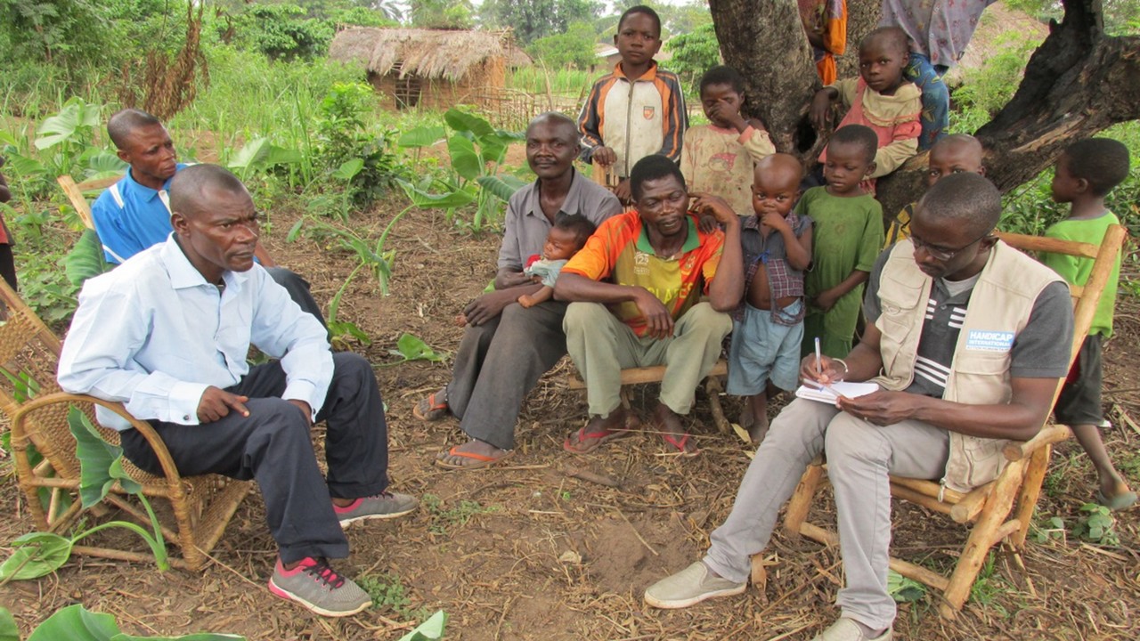 Bakary de Handicap International en RDC en train de prendre des notes sur la situation et les besoins d’une famille de déplacés