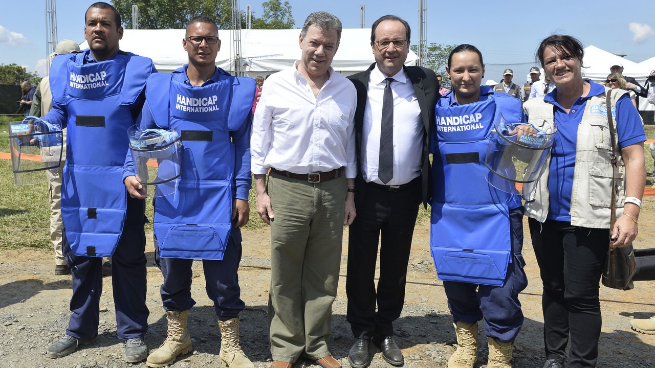 Juan Manuel Santos, Président de la République de Colombie, et François Hollande avec une partie des équipes de Handicap International qui vont déminer les terres en Colombie