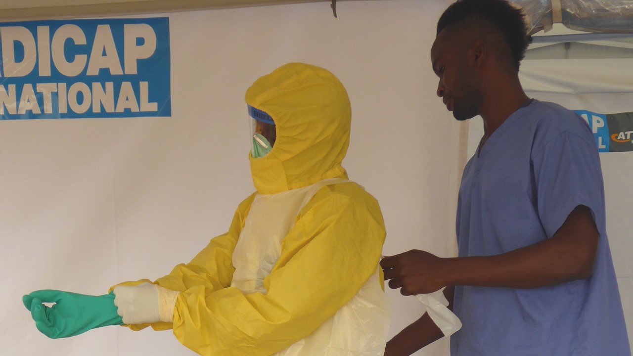 Un homme s'équipe pour aller nettoyer une ambulance intervenue auprès de patients atteints par le virus Ebola.