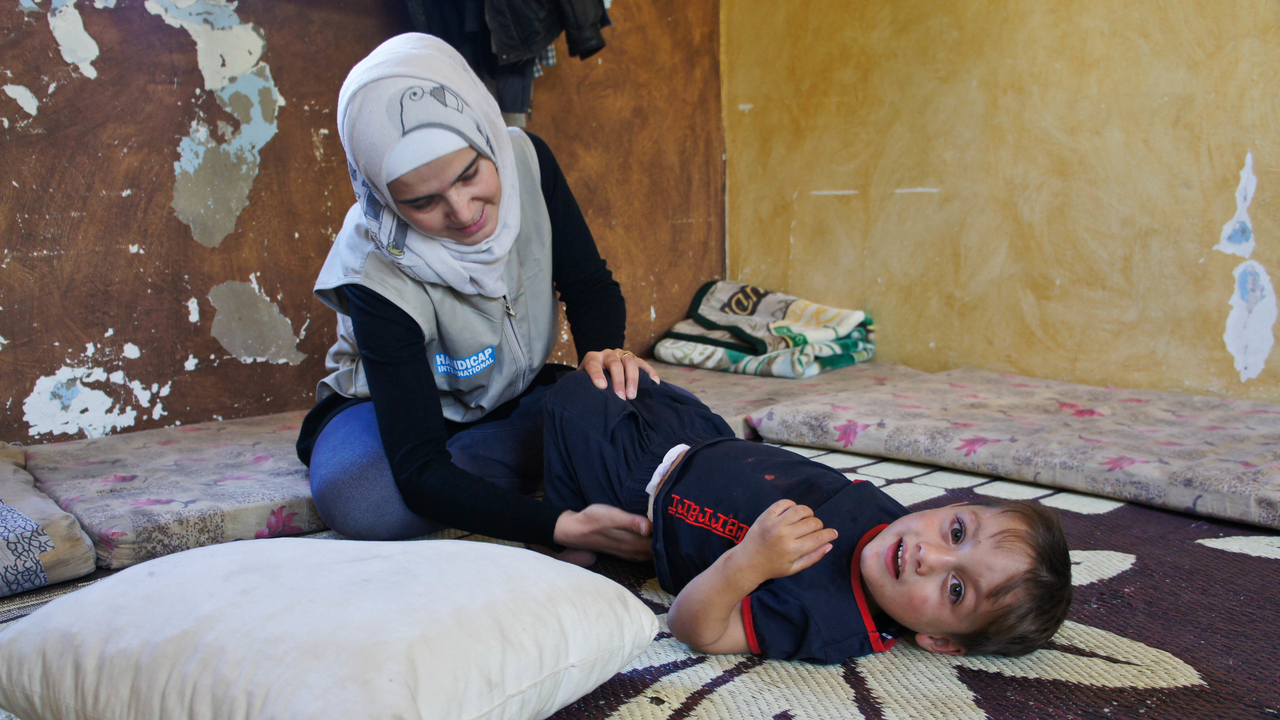 Fayez lors d'une session de réadaptation avec Mariam, kinésithérapeute de Handicap International