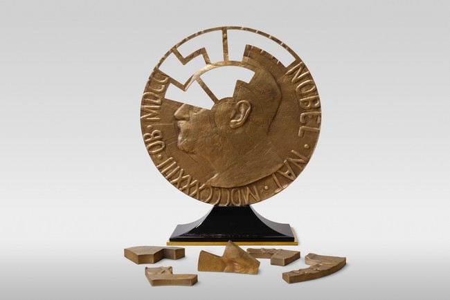Médaille du prix Nobel de la paix fragmentée en plusieurs morceaux.
